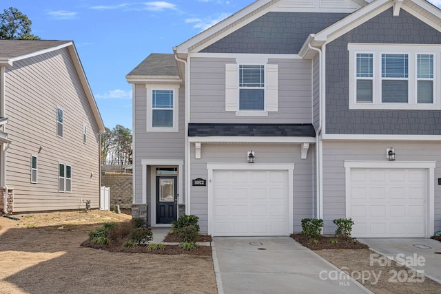 multi unit property featuring driveway and an attached garage