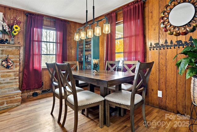 dining room featuring wooden walls and light hardwood / wood-style flooring