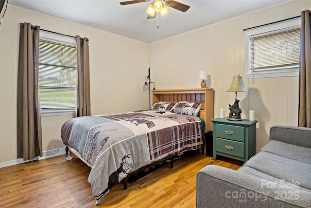 bedroom featuring ceiling fan, ornamental molding, and light hardwood / wood-style floors