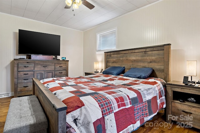 bedroom with dark wood-type flooring, ceiling fan, and ornamental molding