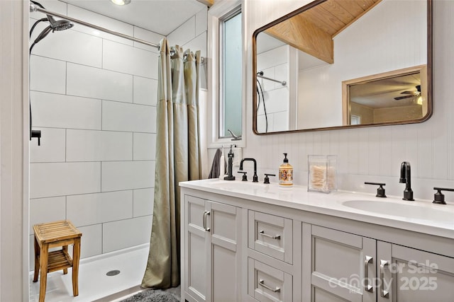 bathroom with ceiling fan, vanity, and curtained shower