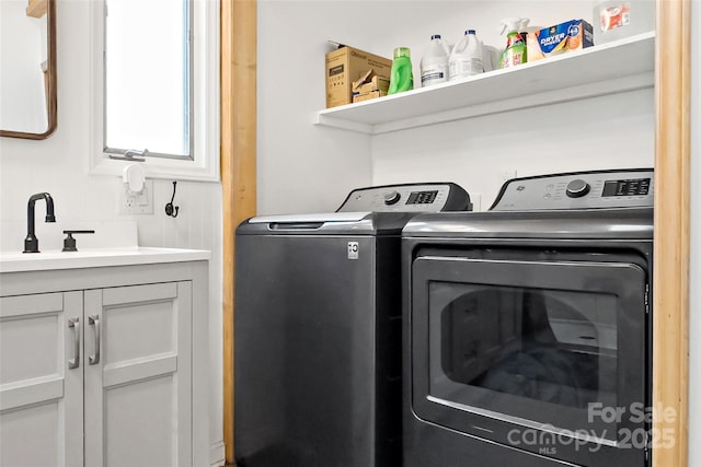 washroom featuring cabinets, washing machine and dryer, and sink