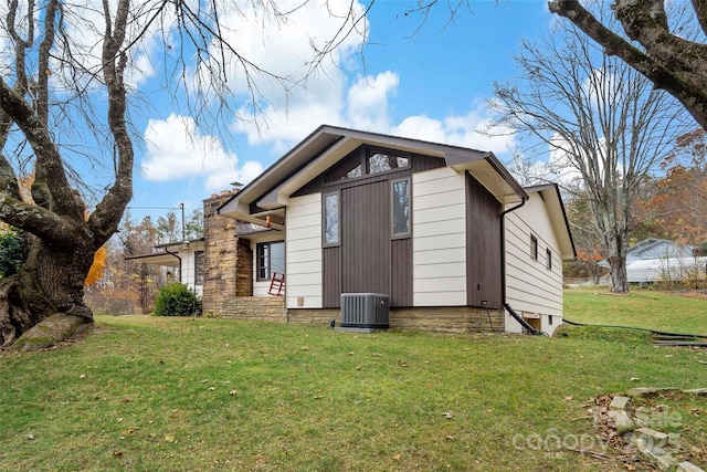 exterior space with central AC unit and a yard