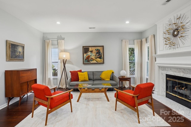 living room featuring hardwood / wood-style flooring and a high end fireplace