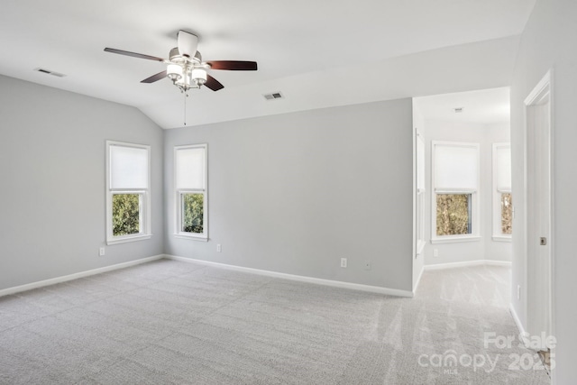 carpeted empty room with vaulted ceiling and ceiling fan