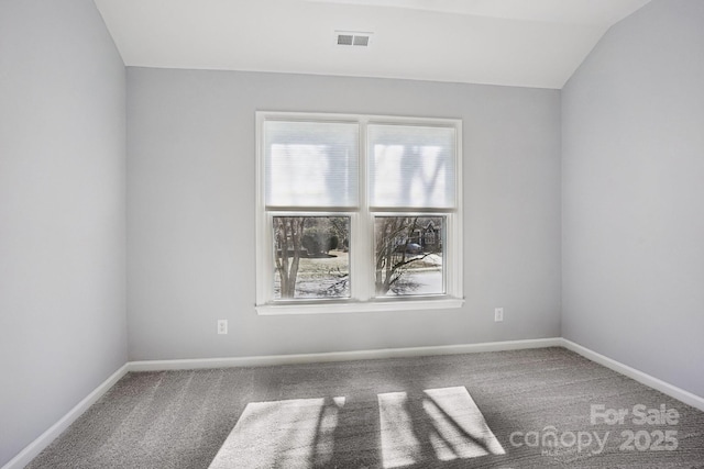 carpeted empty room featuring lofted ceiling