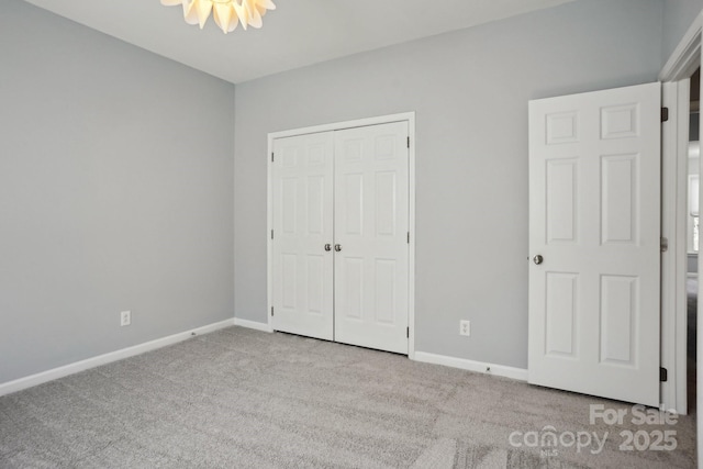 unfurnished bedroom with a closet and light carpet