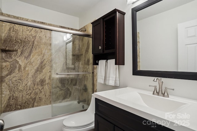 full bathroom featuring enclosed tub / shower combo, vanity, and toilet