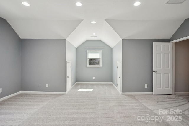 bonus room with lofted ceiling and light colored carpet