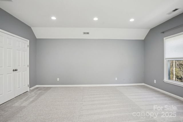 unfurnished bedroom with light carpet and vaulted ceiling