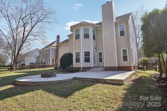 back of house featuring an outdoor fire pit, a patio area, and a lawn