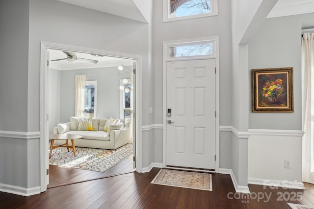 entryway with crown molding, dark hardwood / wood-style floors, and ceiling fan