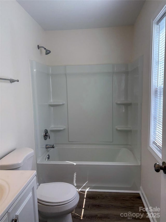 full bathroom featuring washtub / shower combination, vanity, toilet, and wood finished floors