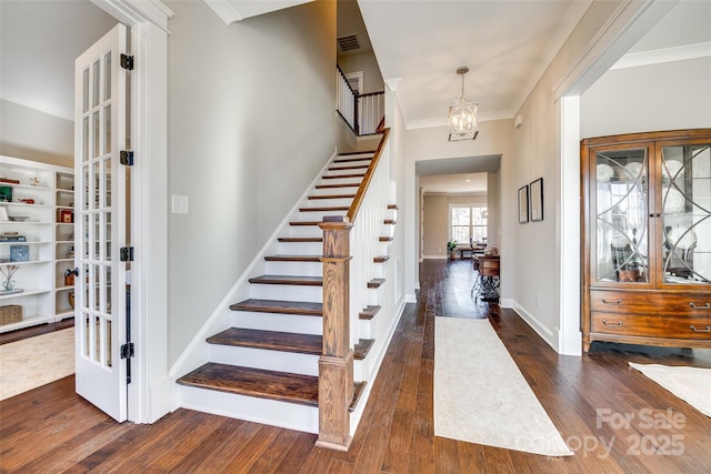 foyer with stairway, dark wood finished floors, visible vents, and crown molding