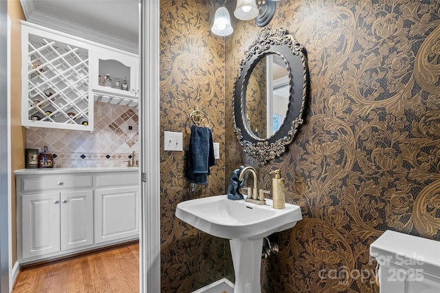 bathroom with sink, hardwood / wood-style floors, decorative backsplash, and toilet