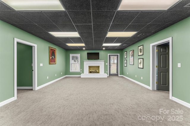 unfurnished living room featuring carpet flooring and a paneled ceiling