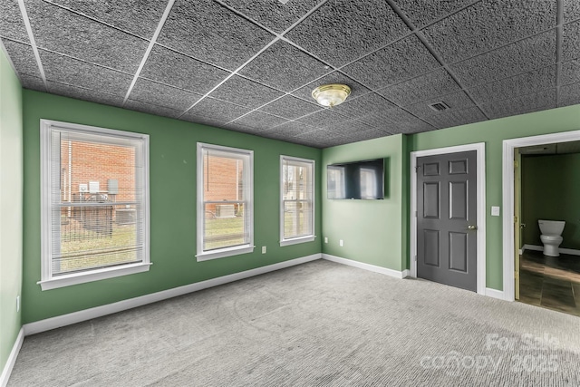 unfurnished room with a paneled ceiling and carpet flooring