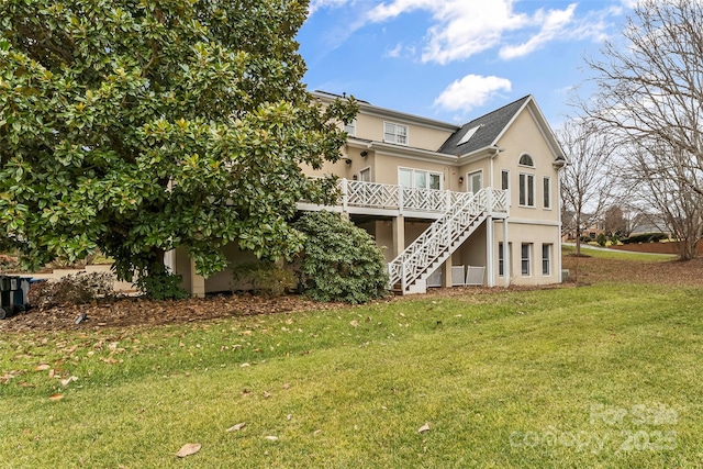 rear view of property with a wooden deck and a yard