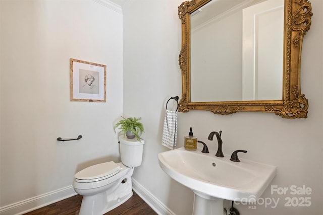 bathroom with toilet, sink, and hardwood / wood-style floors