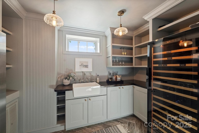 interior space featuring white cabinets, sink, pendant lighting, and wine cooler