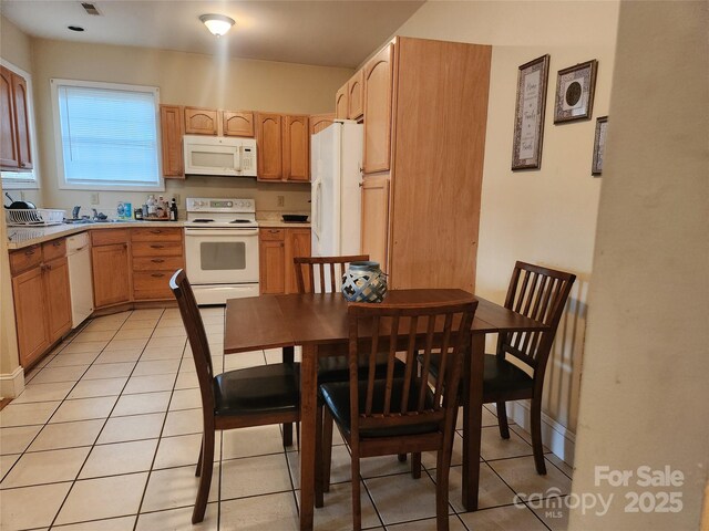 979 W Chapel Rd, Asheville, NC 28803 - kitchen with white appliances, light tile patterned floors, light countertops, and a sink