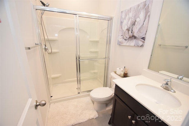 bathroom featuring toilet, vanity, and a shower with shower door