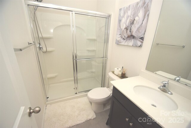 bathroom featuring vanity, toilet, and a shower with door