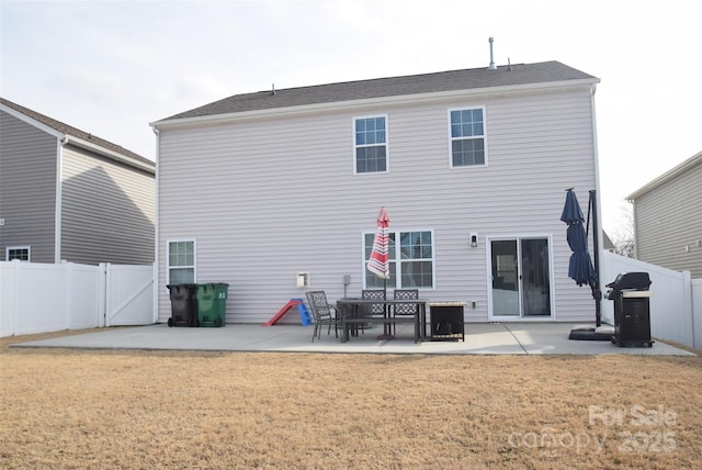 rear view of house with a patio and a lawn