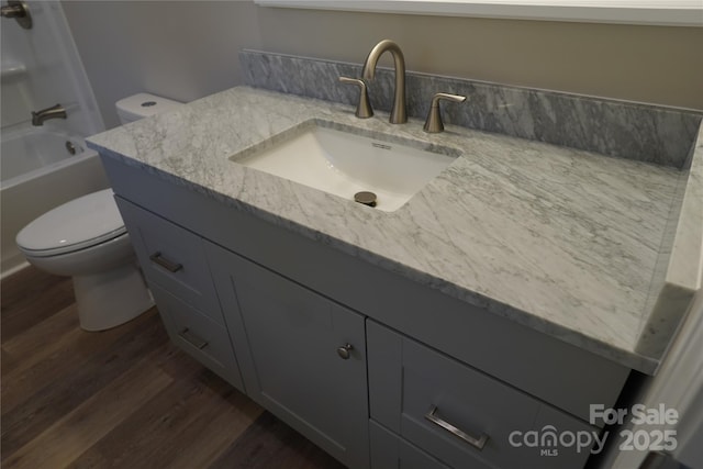 full bathroom with shower / bathtub combination, vanity, toilet, and wood-type flooring