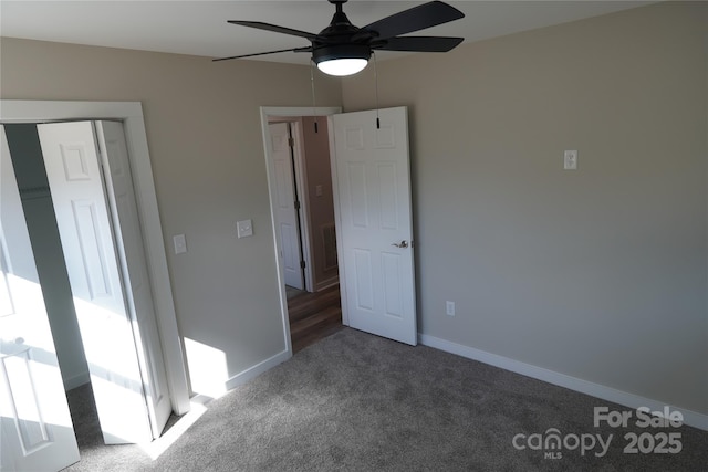 unfurnished bedroom with dark colored carpet and ceiling fan