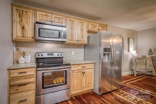 kitchen featuring appliances with stainless steel finishes, light brown cabinetry, backsplash, dark hardwood / wood-style flooring, and light stone countertops