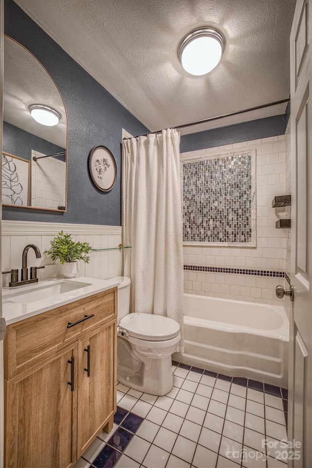 full bathroom with tile patterned flooring, vanity, toilet, shower / bath combo, and a textured ceiling