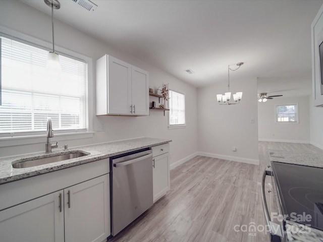 kitchen with appliances with stainless steel finishes, white cabinetry, sink, light stone counters, and light wood-type flooring