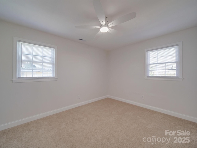 carpeted empty room featuring ceiling fan and a healthy amount of sunlight