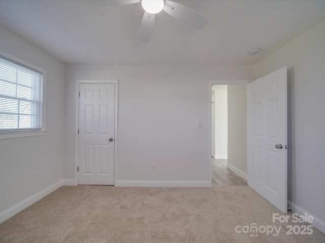 spare room featuring light carpet and ceiling fan