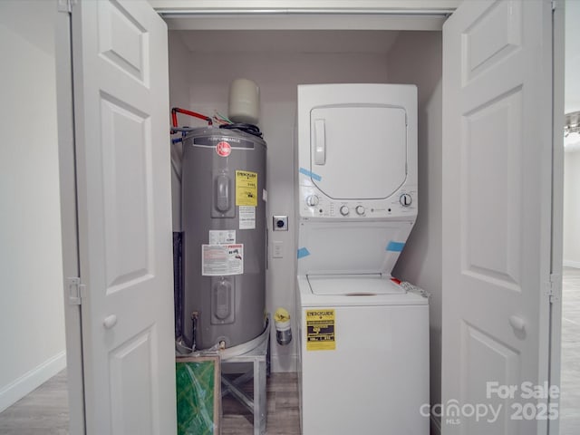 laundry area with stacked washer / dryer, electric water heater, and hardwood / wood-style floors