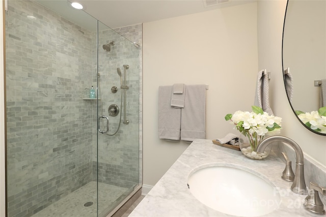 bathroom featuring vanity and a shower with door