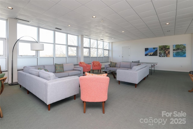 living room featuring carpet flooring and a drop ceiling