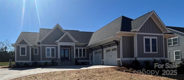 craftsman inspired home with board and batten siding, a shingled roof, driveway, and a garage