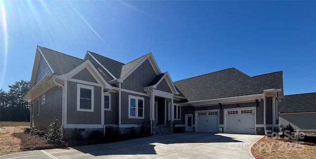 craftsman-style home with board and batten siding, a shingled roof, a garage, crawl space, and driveway