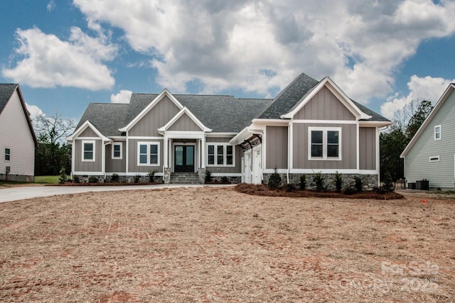 craftsman-style home with french doors, board and batten siding, and a shingled roof