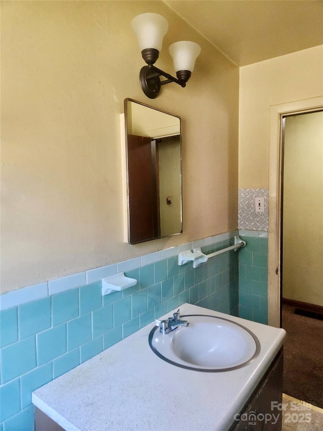 bathroom featuring wainscoting, tile walls, and vanity