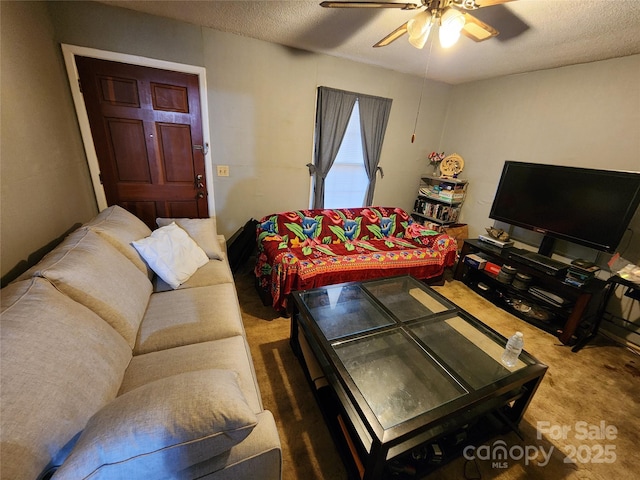 carpeted living room featuring ceiling fan and a textured ceiling