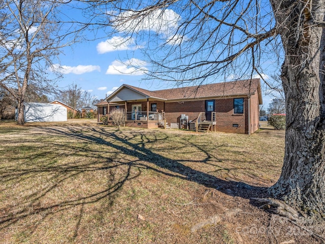 rear view of house with a porch and a lawn