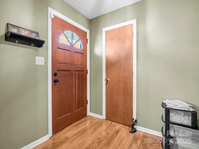 foyer featuring light hardwood / wood-style flooring and a textured ceiling