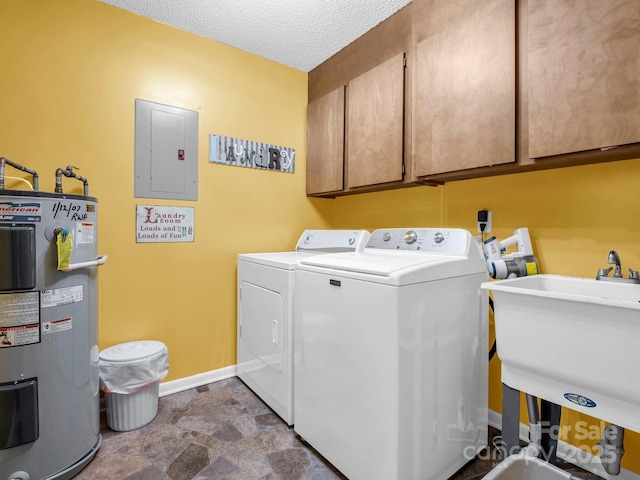 laundry area featuring water heater, sink, cabinets, electric panel, and washer and clothes dryer