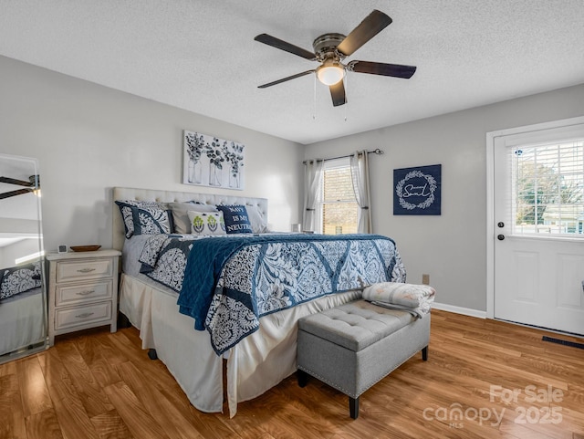 bedroom featuring ceiling fan, a textured ceiling, and light wood-type flooring