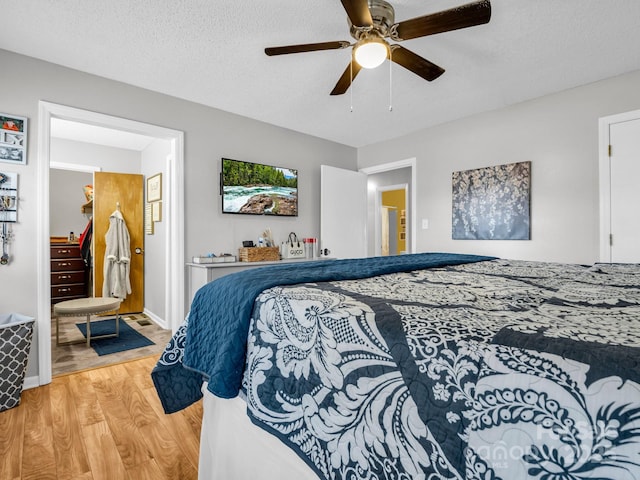 bedroom with ceiling fan, a textured ceiling, and light wood-type flooring