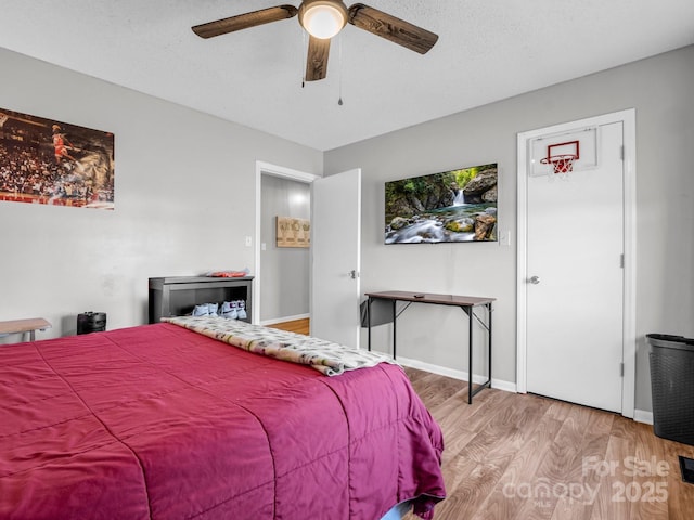 bedroom featuring ceiling fan, wood-type flooring, and a textured ceiling