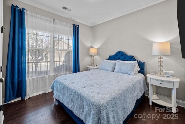 bedroom with ornamental molding and dark hardwood / wood-style floors